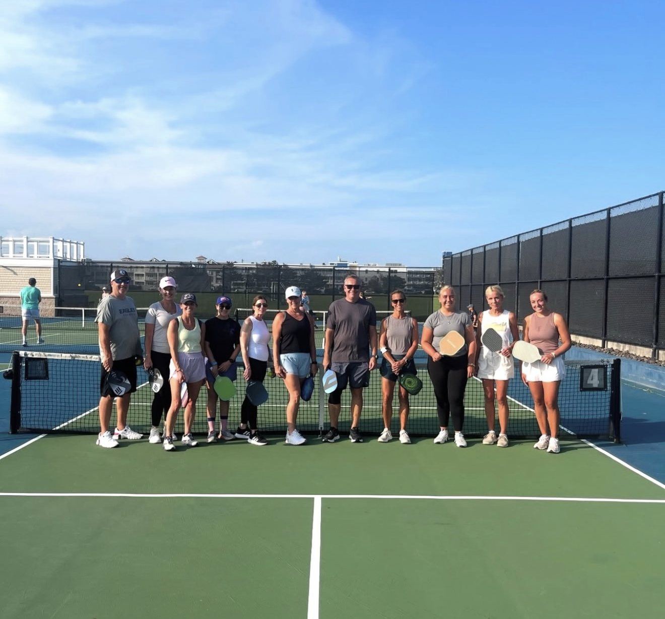 A full adult pickleball clinic on a sunny Jersey Shore court
